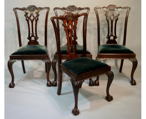 A set of four Chippendale revival dining chairs with foliate carved top rails, waisted "Gothic" splats, drop-in seats upholst