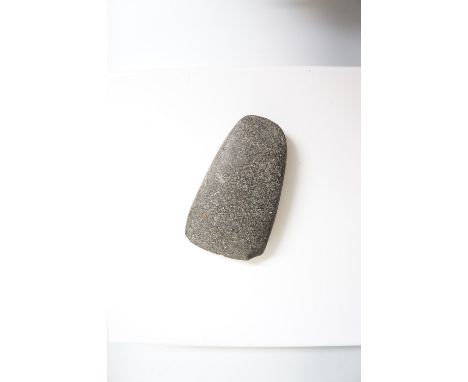 A Neolithic granite axe head, 15cm wide (chipped)