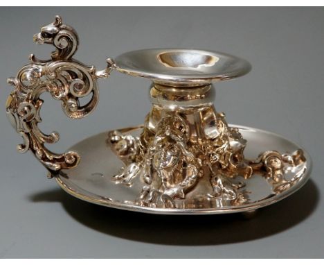 An American Art Nouveau silver candlestick, scrolling foliate handle with roaring lion's head uppermost, three ladies head's 