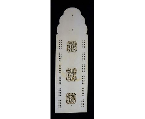 A Canton ivory cribbage board of shaped rectangular outline the centre finely relief carved with three shaped rectangular pan