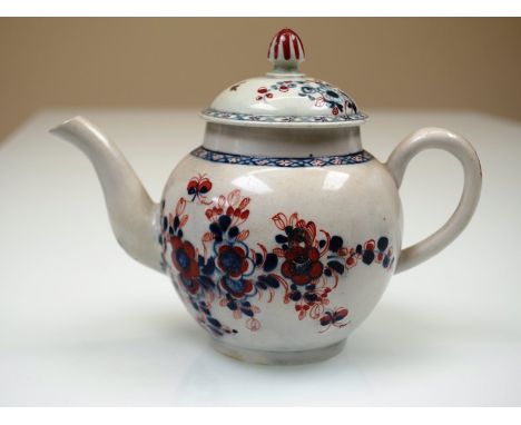 An 18th Century Lowestoft porcelain teapot of small proportions with dome lid and spherical body painted in blue and iron red