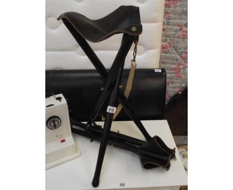 A pair of quality leather topped tripod folding stools with carry handles
