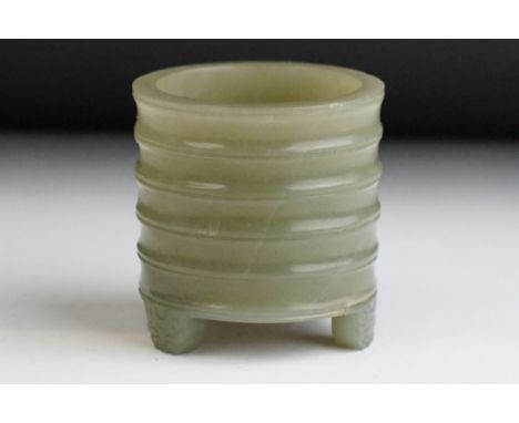 A Chinese antique jade three footed brush pot with ribbed decoration. 