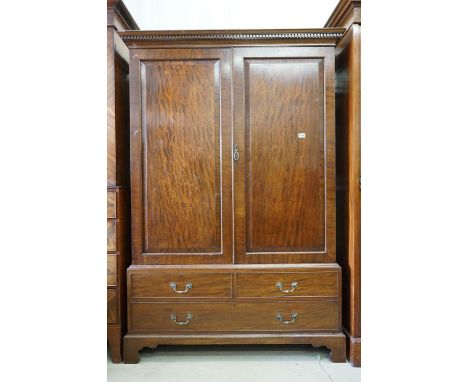 George III style Mahogany Wardrobe, the two panel doors opening to a hanging space with brass rail and hooks, over two short 