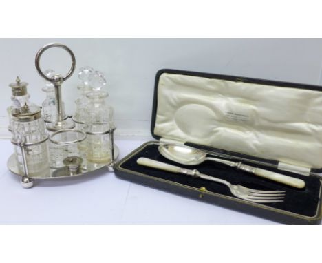 A six bottle plated cruet (five bottles plus one top) and a serving spoon and fork with associated case