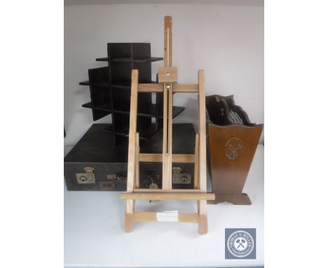A vintage leather luggage case together with a wall shelf, artist's easel and magazine rack