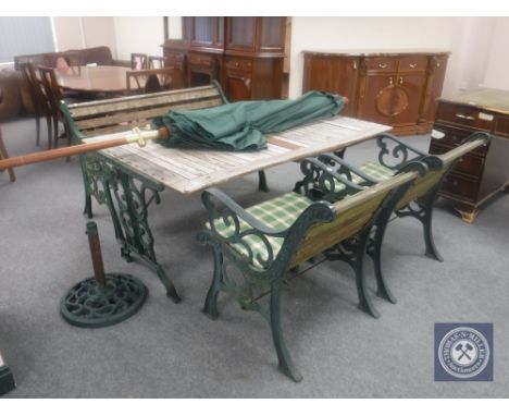 A cast iron and wood rectangular garden table together with a bench, two armchairs and parasol with base