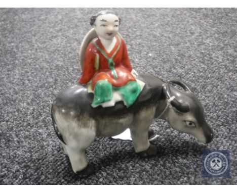An early 20th century Chinese pottery figure of a man seated on a water buffalo, height 13.5 cm.