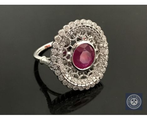 An 18ct white gold ruby and diamond ring, featuring one round cut natural ruby 1.23ct with 70 round brilliant cut diamonds 0.