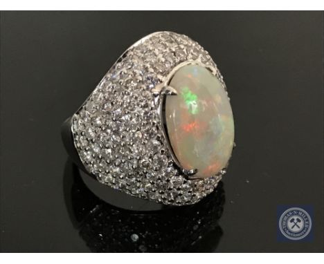 An 18ct white gold opal cocktail ring featuring a cabochon opal 4.12ct amd 145 single cut diamonds pave set 2.45ct.