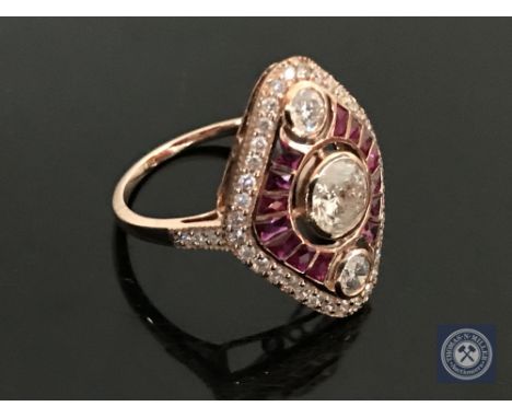 A 14ct rose gold ruby and diamond ring, featuring 1 round brilliant cut diamond 0.51ct, 2 round cut brilliant diamonds 0.18ct