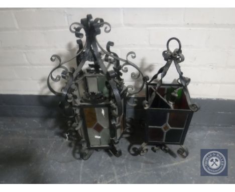 Two wrought iron hanging light fittings with leaded glass shades 