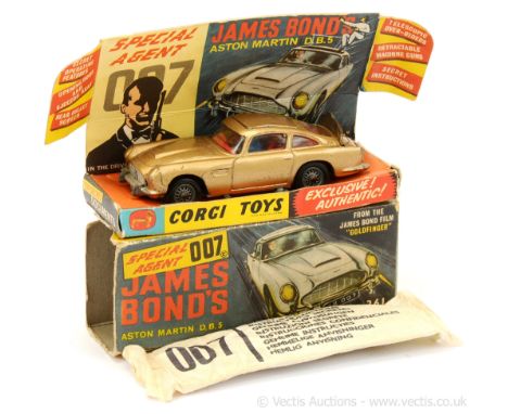 Corgi 261 "James Bond" Aston Martin DB5 taken from the film "Goldfinger" - gold body, red interior with "James Bond and Bandi