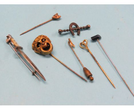 A novelty gilt-metal stick-pin, mask with moving parts, four other stick pins, novelty dagger bar-brooch and a silver horsesh