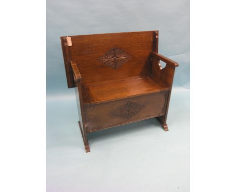 A solid, dark oak monk's bench, top with incised carved detail, panelled cupboard base, 3ft. 