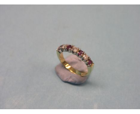 An 18ct. gold diamond and ruby half-eternity ring, three diamonds, four rubies, claw settings, size L 