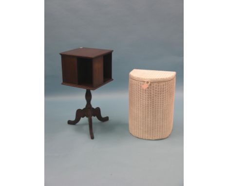 A mahogany revolving bookcase, on tripod base, and a cream-sprayed Lloyd Loom linen basket