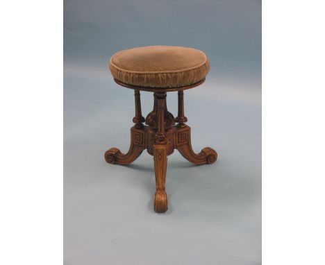 A Victorian walnut revolving piano stool, upholstered seat on fluted, columnar tripod base, original price label attached, 44