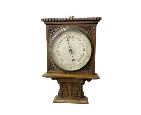 Edwardian - oak cased Arts and Crafts aneroid barometer with an 8” register, carved case with a flat top and dentil moulding,