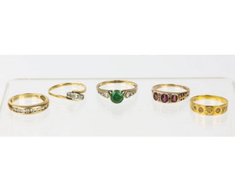 Five gem set rings, a hallmarked gold ring in 18ct, size M½, a three stone diamond ring in a crossover design, in tested 18ct