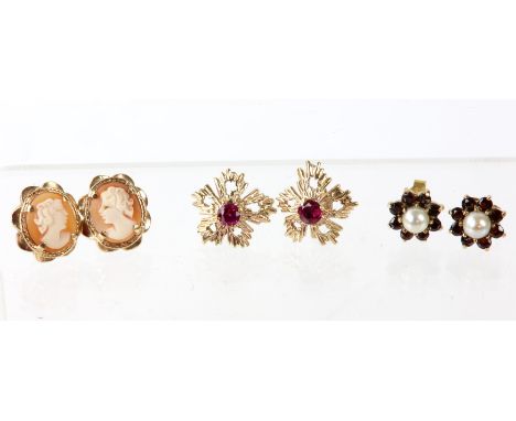 Three pairs of stud earrings, including a leaf design pair set with a small ruby to the centre, a pearl and garnet cluster pa