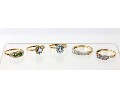 Five dress rings, including a blue topaz cluster ring set with an oval blue topaz and a surround of round cut white cubic zir