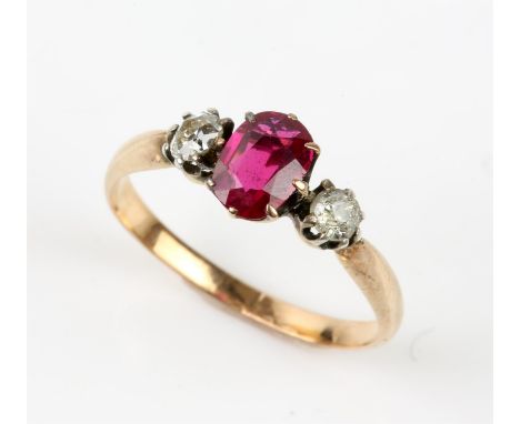 Synthetic ruby and diamond three stone ring, oval cut synthetic ruby with an old cut diamond set either side, mounted in test