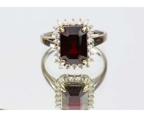 Red spinel and diamond cluster ring, an emerald cut red spinel weighing 4.24 carats, with a surround of round brilliant cut d