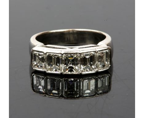 Five stone diamond ring, five graduating emerald cut diamonds, rubover set in tested 18ct white gold, estimated total diamond