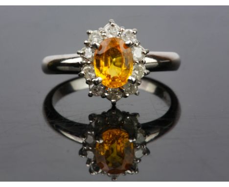 Yellow sapphire and diamond cluster ring, an oval cut yellow sapphire, estimated sapphire weight 0.92 carat, with a surround 