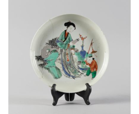 A CHINESE FAMILLE-VERTE DISHKangxi Painted with a woman seated holding a scroll, a boy standing beside carrying a chime, apoc