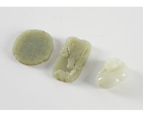 THREE CHINESE JADE CARVINGS (3)Comprising; a pale celadon jade carving of a recumbent cat, 4cm wide; a celadon jade pendant c