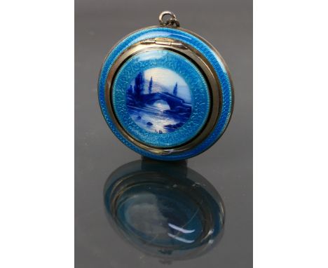 A continental guilloche enamel miniature compact with a picture of a bridge on the lid and a fitting for a chain. The teal co