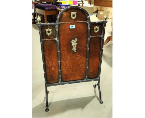 An Arts and Crafts beaten copper and steel fire screen with brass highlights, ht 77cm 