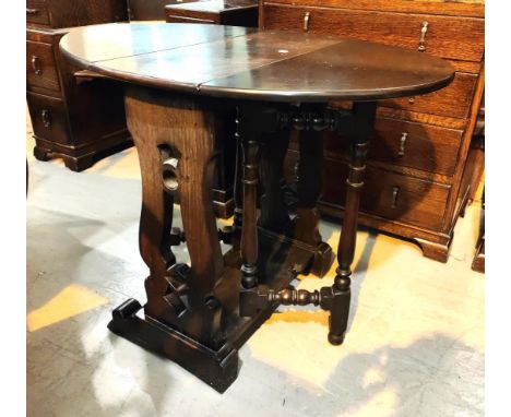 A good quality oak drop leaf oval topped table with harp shaped carved supports to each side, feet shorter on one side to fit