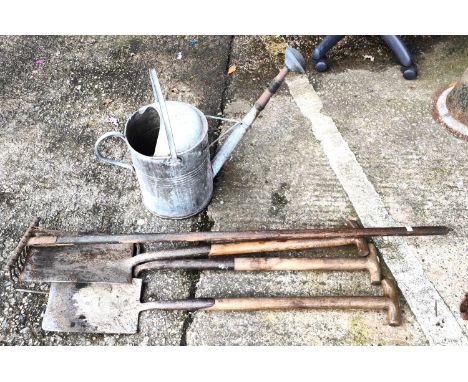 A galvanised steel vintage watering can and a selection of vintage garden tools 