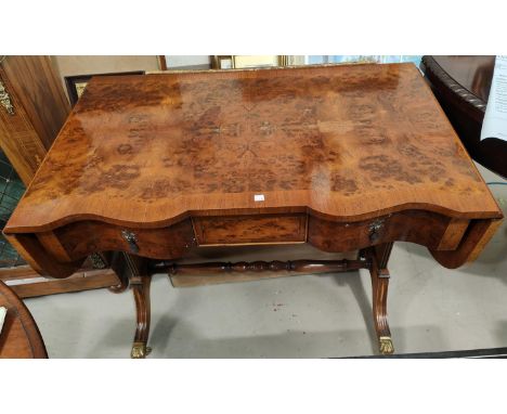 a Regency style X band burr walnut sofa table with serpentine front, 3 frieze drawers, 4 splay feet and brass casters width 9