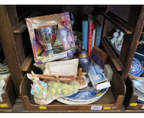 A Peter Rabbit figure by a wheelbarrow, Harry Potter Magic Chalice, various books on magic and other ornaments 