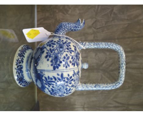 A Chinese blue and white wine pot, scale decorated handle and spout with flowering tree panels and pedestal foot, 18th centur