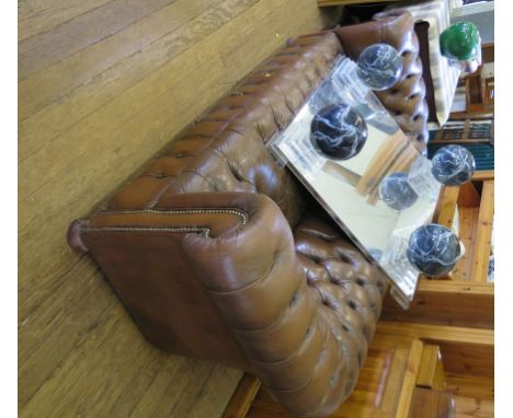 A brown leather Chesterfield sofa on turned feet, 200cm wide