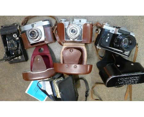Four cameras including a Kodak folding camera, Zenit-E, Koroll 24 and a light meter