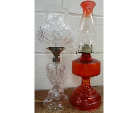A red glass oil lamp and a clear glass table lamp