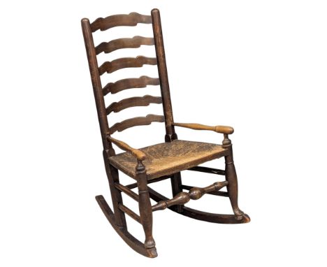 A 19th Century Victorian elm rocking chair. With rush seat and ladder back. C. 1860-1880.