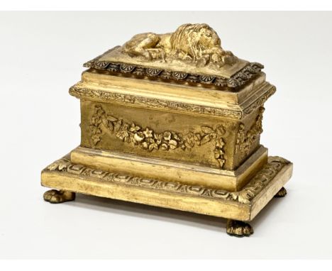 A 19th Century Victorian gilt wood sarcophagus jewellery casket. With a recumbent lion cover, gilt brass acanthus leaf border