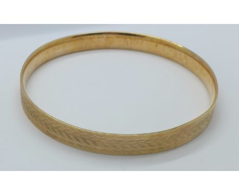 A 9ct gold metal core bangle