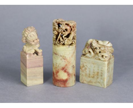 A Chinese soapstone desk seal with carved lion-dog handle, 4” high; &amp; two similar soapstone seals with carved &amp; pierc