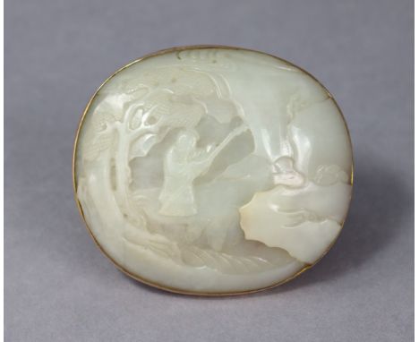 A Chinese white jade roundel, relief-carved with an immortal in a landscape, 2¾” x 3”, set to a yellow-metal brooch mount.