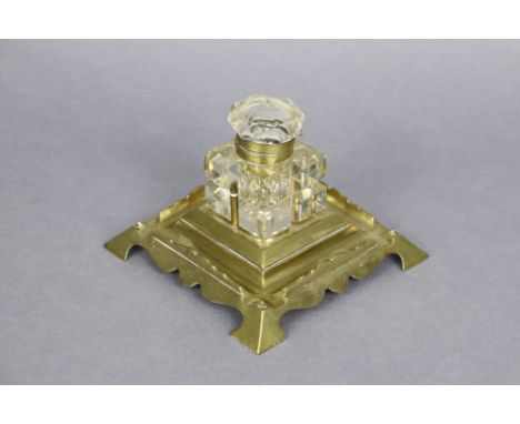 A late 19th/early 20th century brass inkstand fitted cut-glass square inkwell with brass mounts (lid detached), 6½” square x 