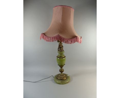 A Brass and Onyx Table Lamp with Seated Cherub Mounts and Pink Shade