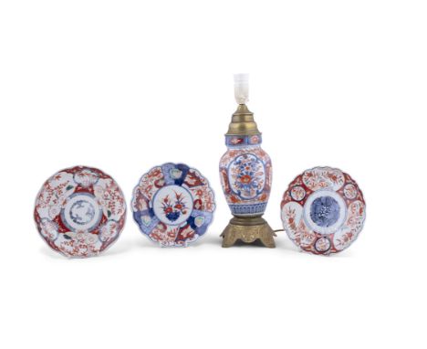 A JAPANESE IMARI AND GILT METAL LAMP,37cm high, with three Imari dishes (E)ELECTRICAL GOOD IN NEED OF REWIRING ARE INDICATED 